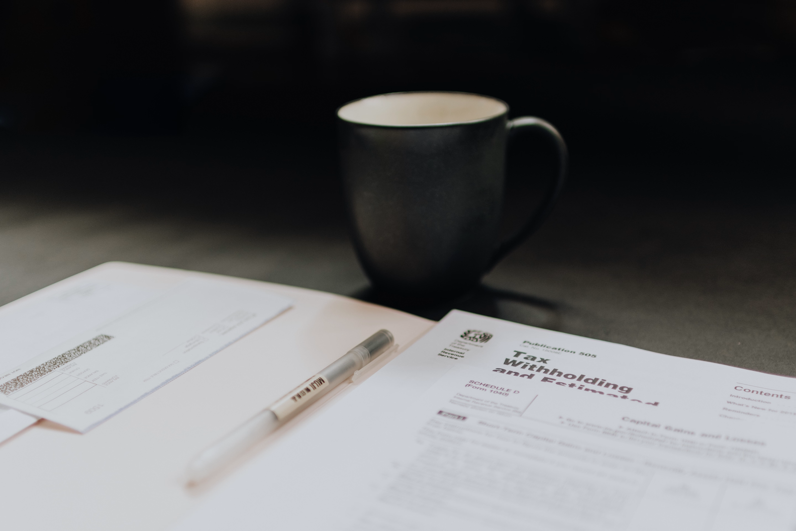 Taza de café junto a documentos financieros sobre un escritorio
